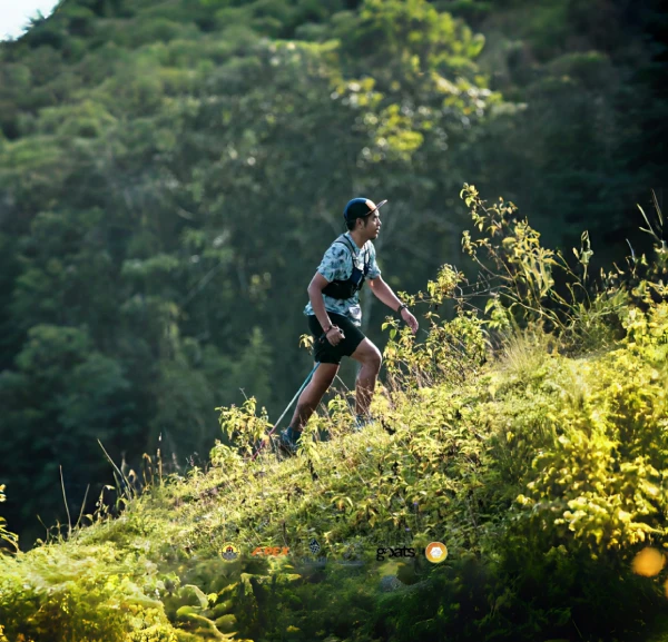 A man standing on top of a lush green hillside.